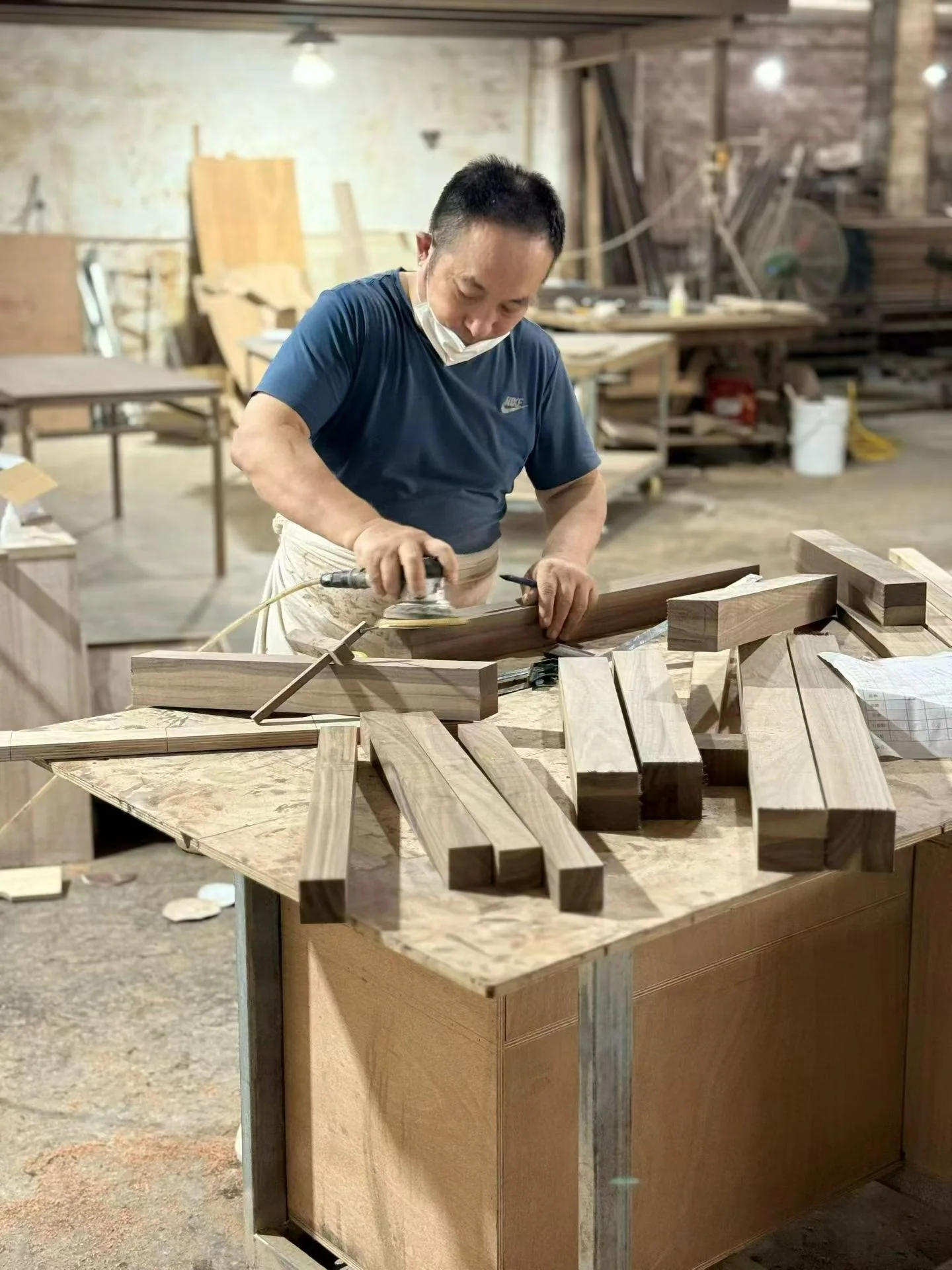 A worker sanding a wooden furniture component