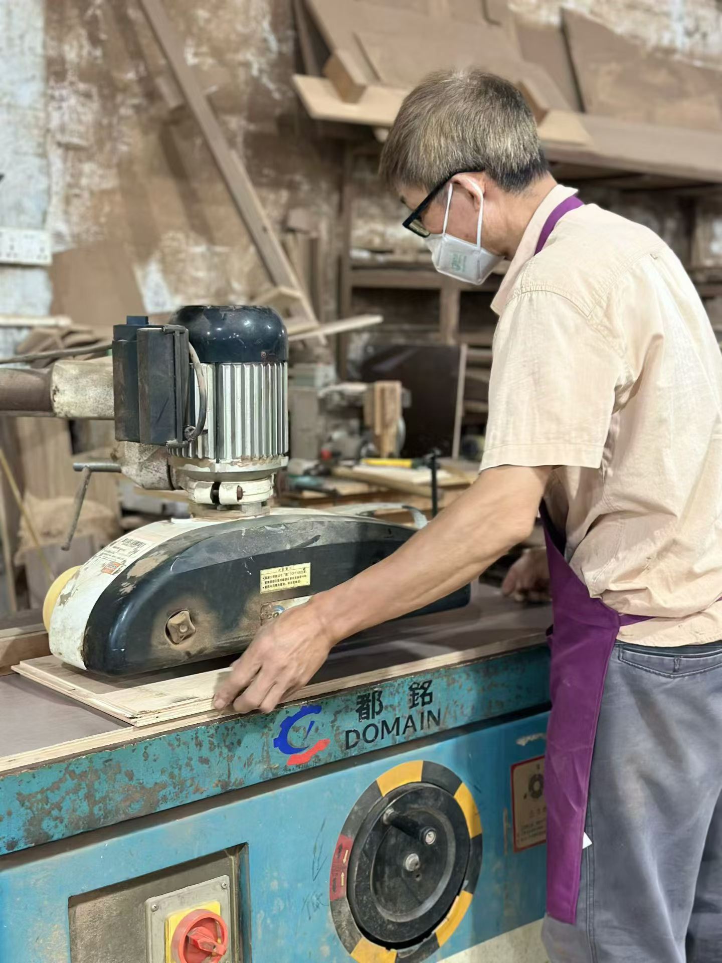 A craftsperson operating a sanding machine in a workshop